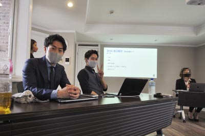 スクリーンの前で自己紹介の進行をする社員2人