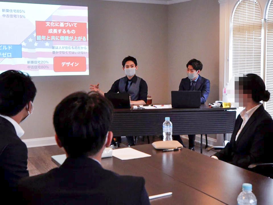 スクリーンの資料を見ながら説明を聞く内定者たち