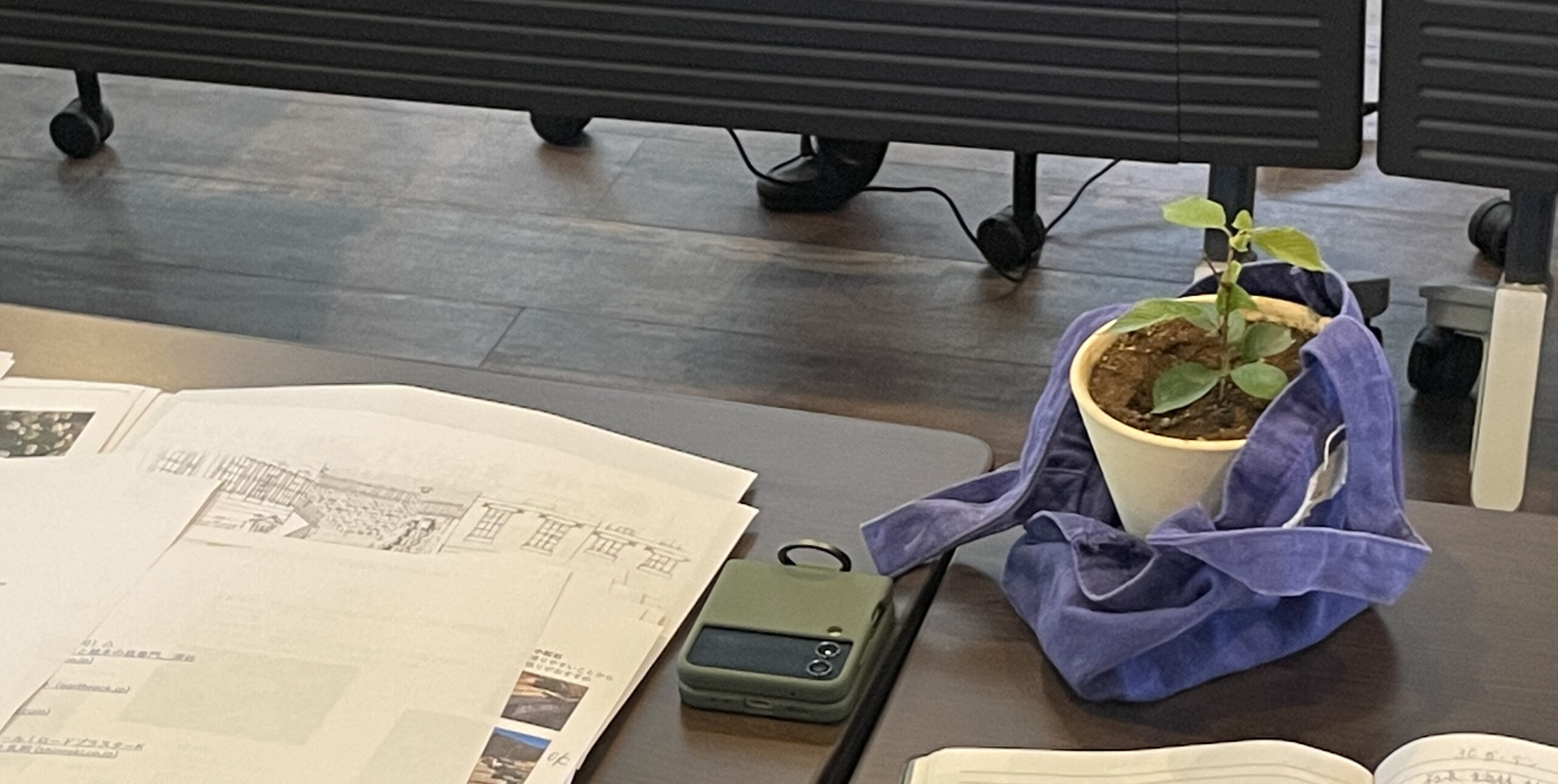 会議机に広げられた図面と鉢植え