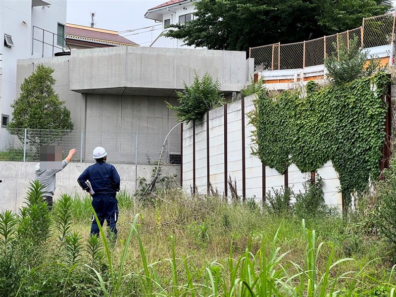 敷地内で山留めの位置を確認する2人