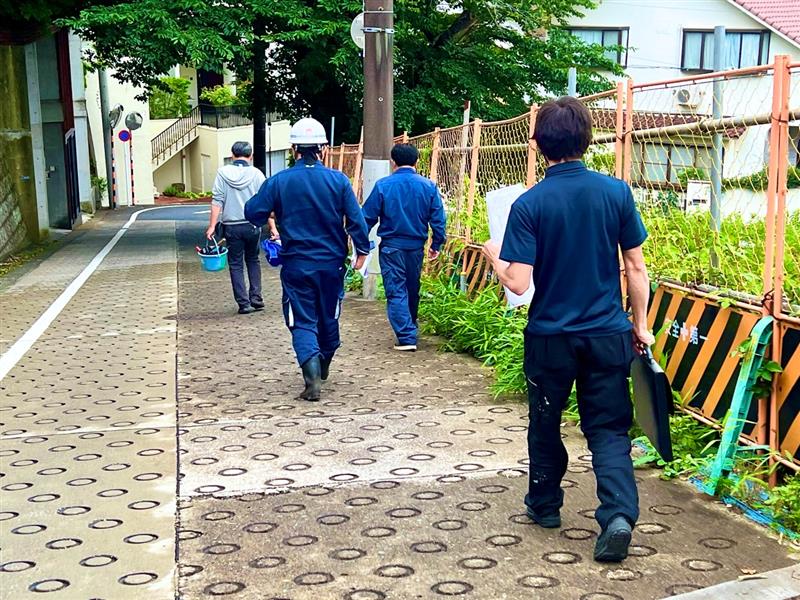 現場へ向かうプロジェクトメンバーの後ろ姿