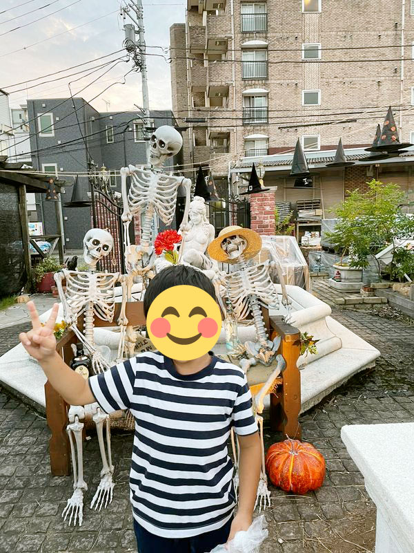 骸骨の装飾の前で写真におさまる来店者