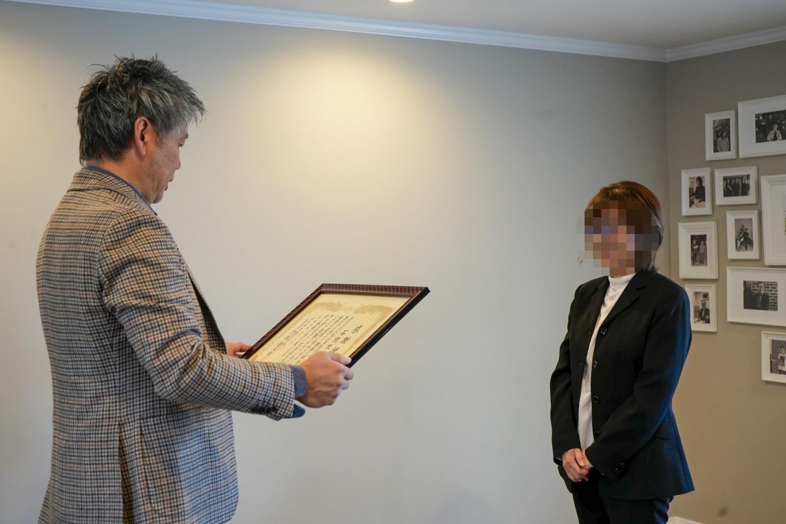 表彰状を読み上げる社長と、それを聞く発注センターのIさん