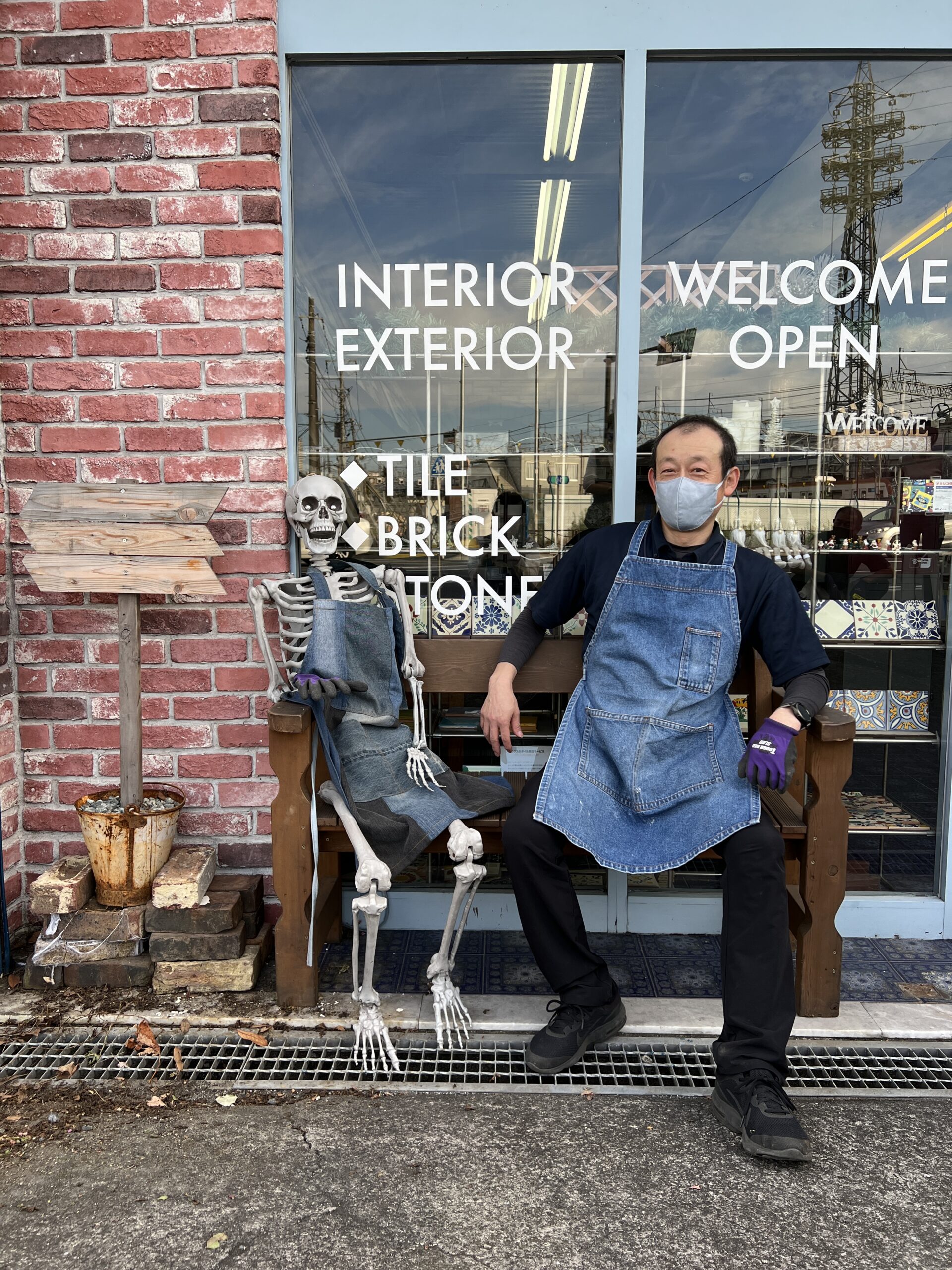 店頭のベンチに座る社員と骸骨
